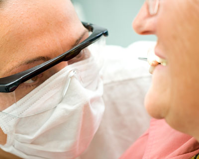 A doctor examining the dentures of an elderly patient